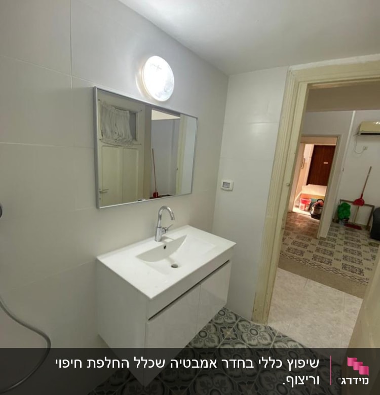 חדר אמבטיה משופץ עם כיור חדש ומראה